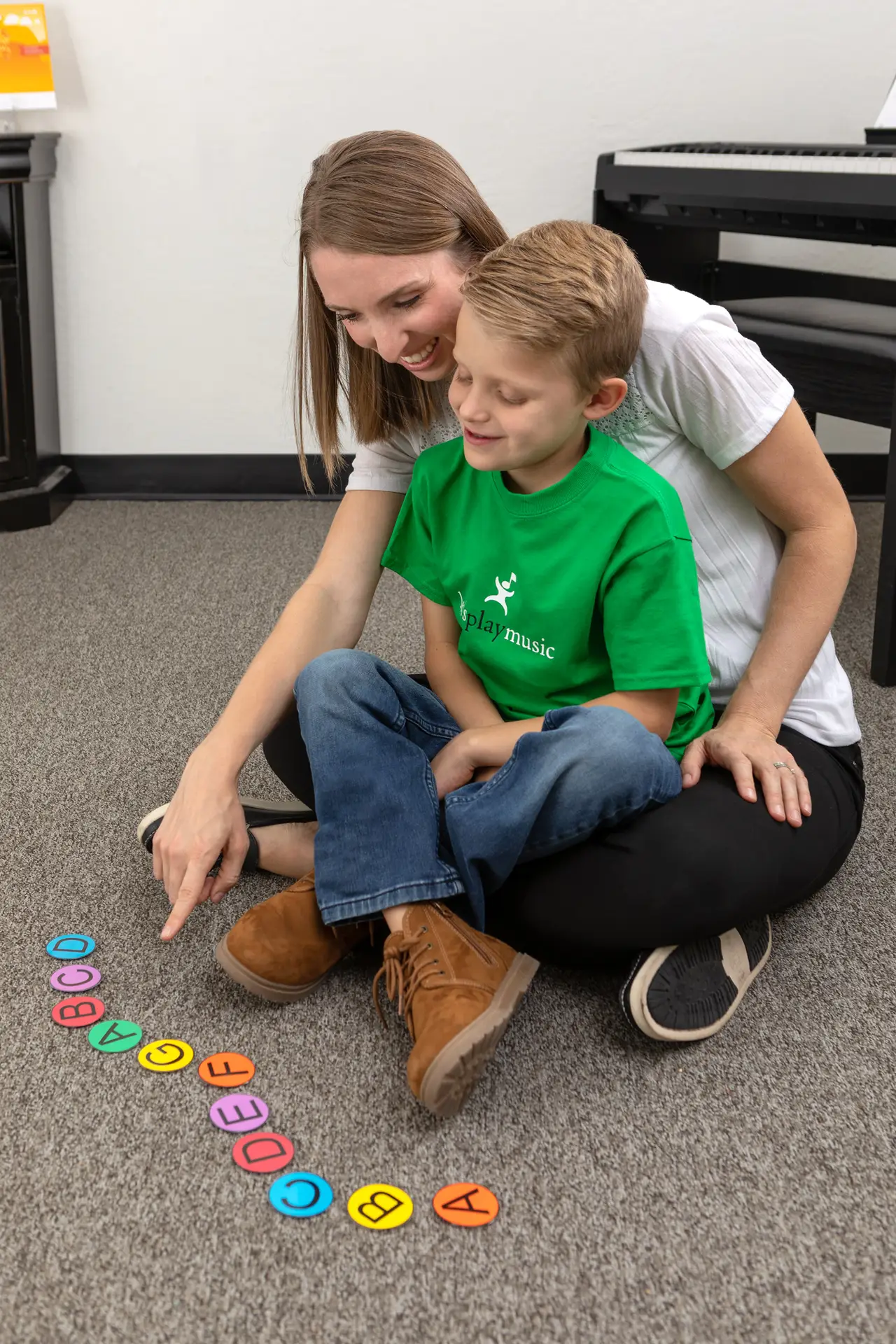 A woman teaching a young boy music concepts