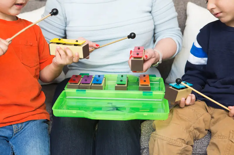 two young boys playing a musical instrument.